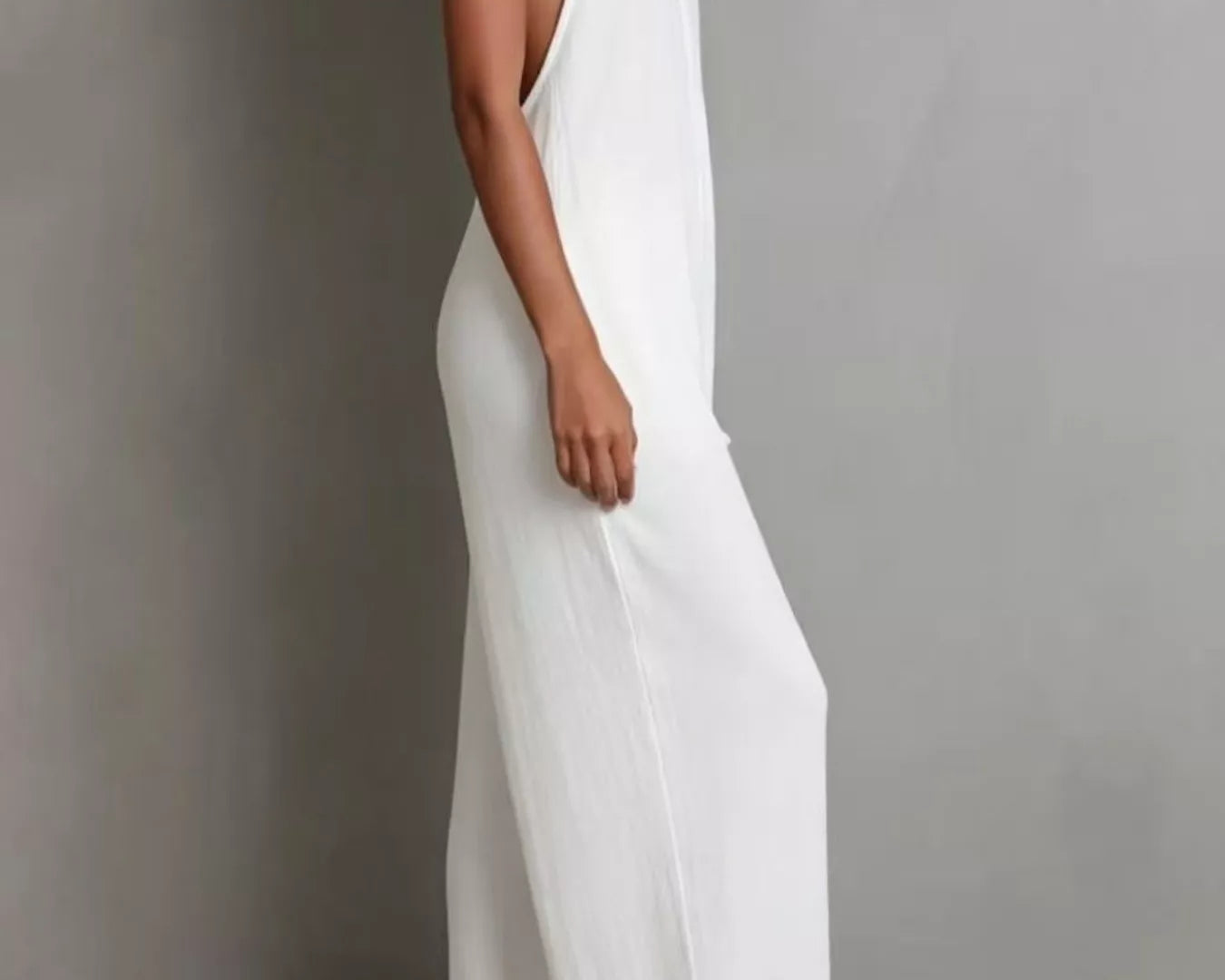 NEWYORKLISTED STYLE COLLECTION: Woman wearing a white sleeveless dress against a gray background