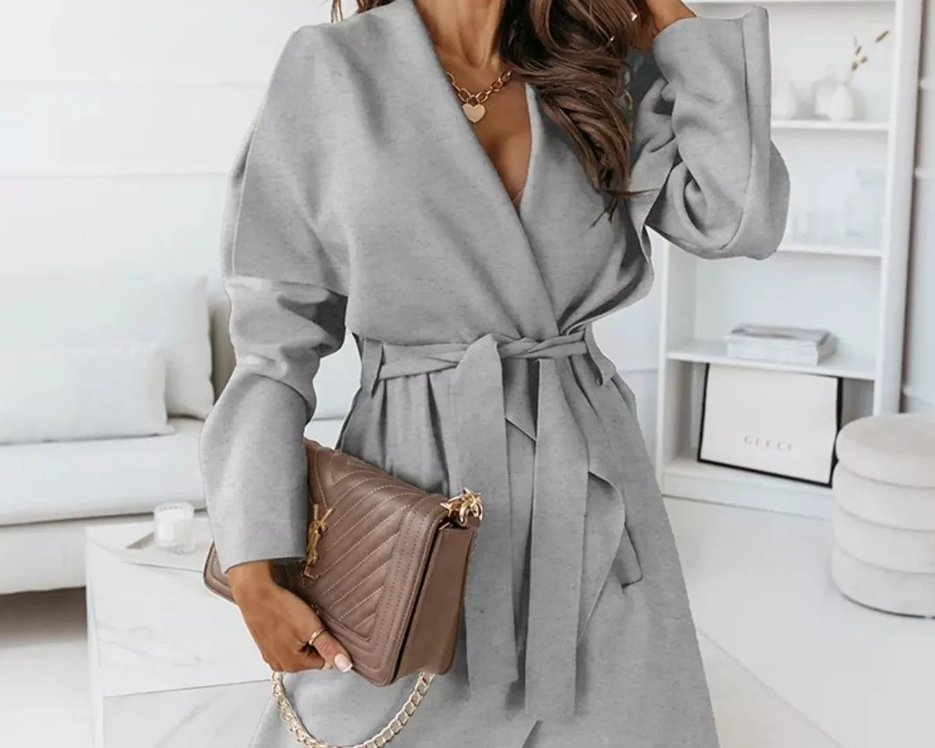 NEWYORKLISTED STYLE COLLECTION: Woman wearing a gray coat in a modern living room