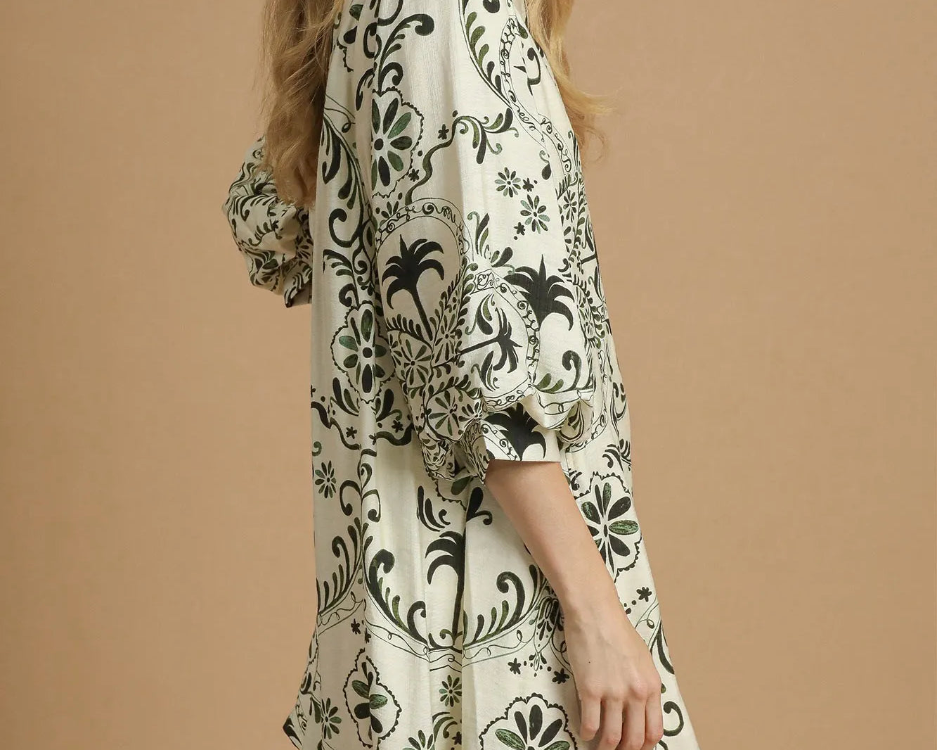 NEWYORKLISTED STYLE COLLECTION: Woman wearing a patterned dress on a beige background