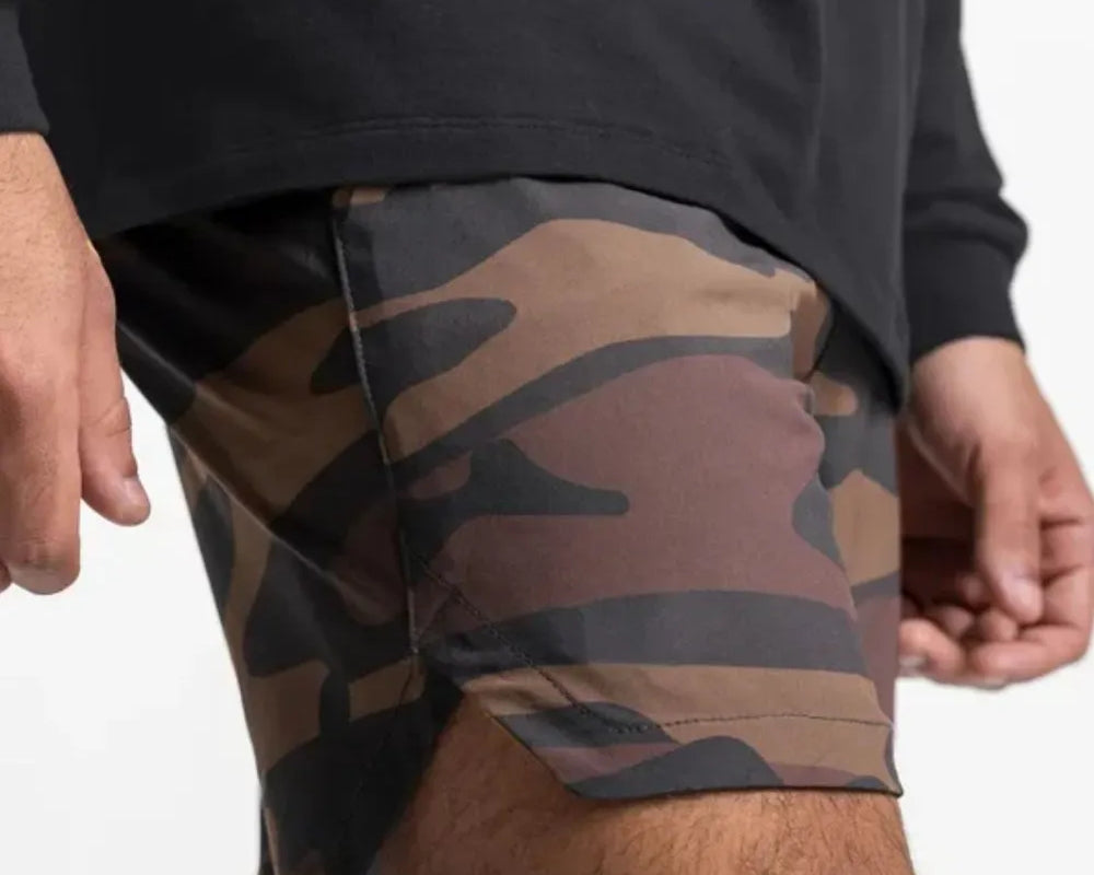 NEWYORKLISTED ATLAS MEN'S COLLECTION: Person wearing camouflage shorts and a black long-sleeve shirt on a white background