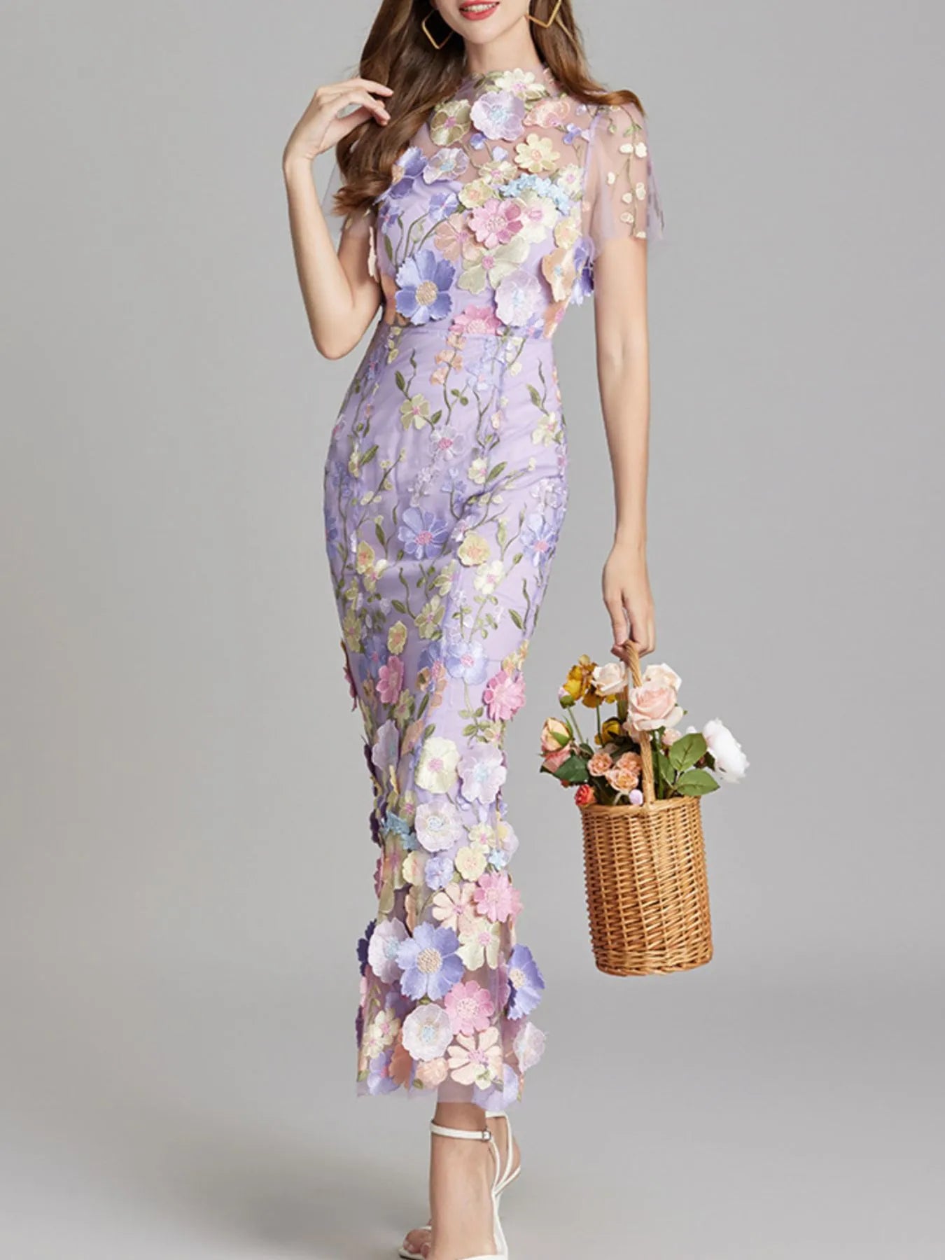 NEWYORKLISTED STYLE COLLECTION: Woman wearing a floral dress holding a basket of flowers on a gray background