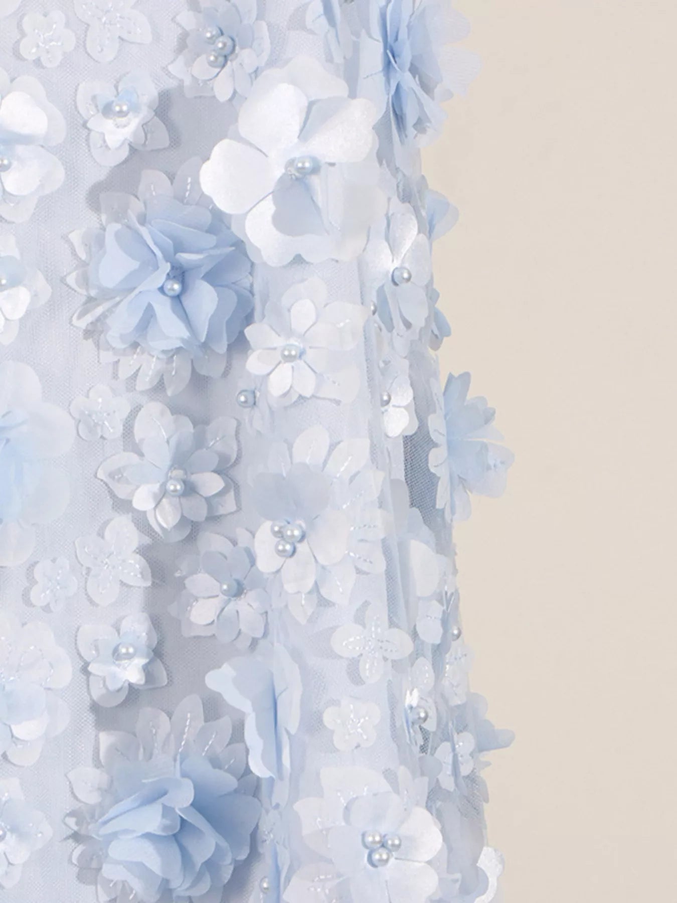 NEWYORKLISTED STYLE COLLECTION: Close-up of a decorative floral garland with light blue and white flowers on a neutral background