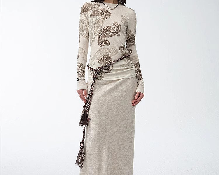 NEWYORKLISTED STYLE COLLECTION: Woman wearing a long, elegant dress with intricate patterns on a white background