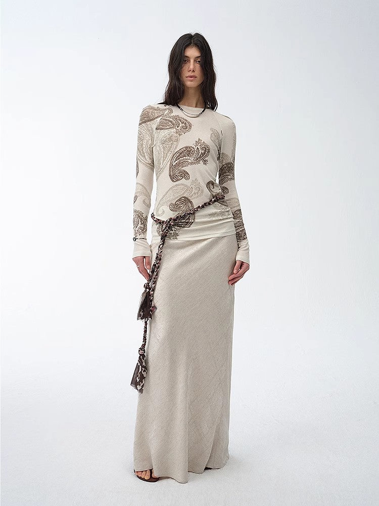 NEWYORKLISTED STYLE COLLECTION: Woman wearing a long, elegant dress with intricate patterns on a white background