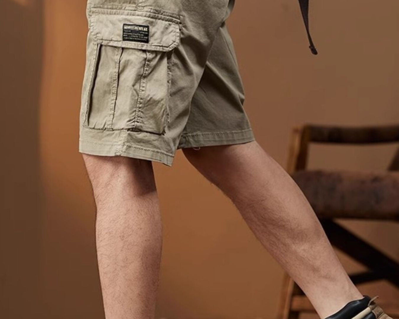 NEWYORKLISTED ATLAS MEN's COLLECTION: Person wearing khaki cargo shorts and brown boots indoors.