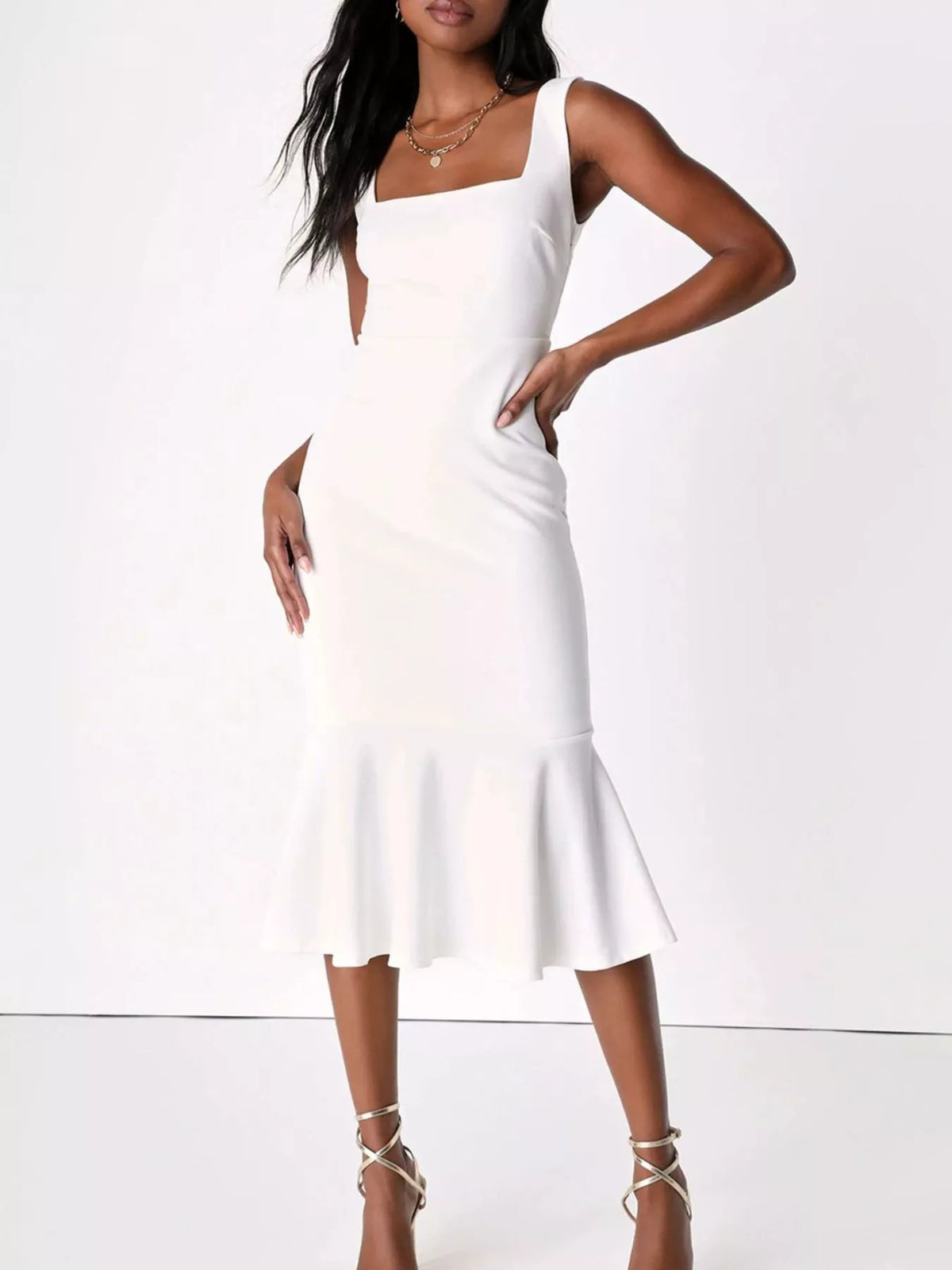 NEWYORKLISTED STYLE COLLECTION: A woman modeling a white sleeveless midi dress with a square neckline, side cutout, and flared ruffle hem against a plain white studio background.