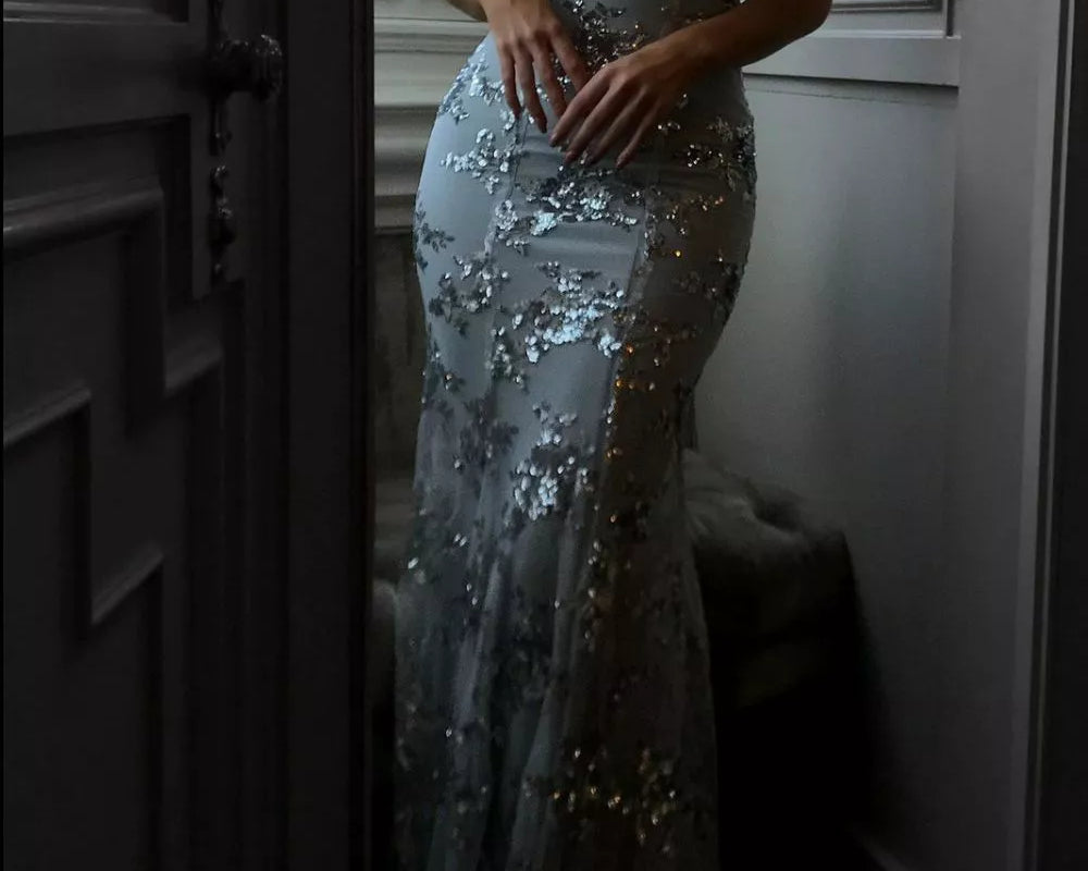 Woman wearing a silver sequin evening gown in a room.