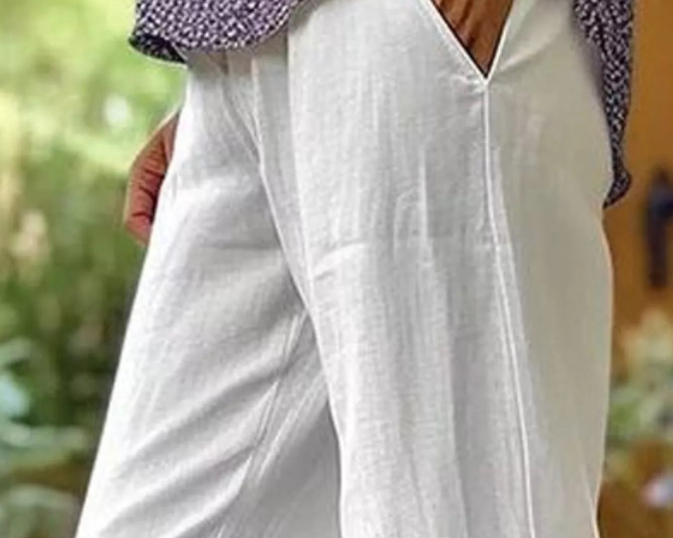 NEWYORKLISTED STYLE COLLECTION: White wide-leg linen pants with side pockets, worn by a model in an outdoor setting.