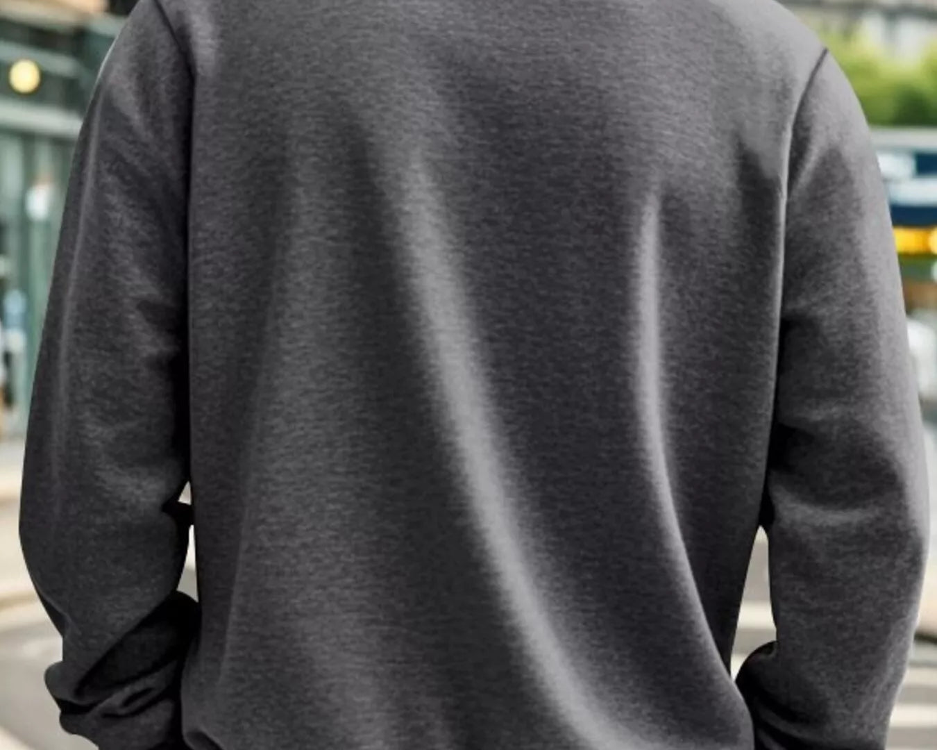 NEWYORKLISTED ATLAS MEN'S COLLECTION: Person wearing a gray jacket with a blurred urban background