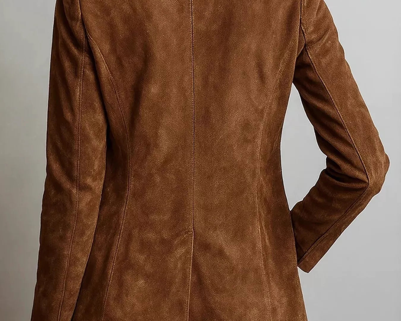 NEWYORKLISTED STYLE COLLECTION: A woman shown from the back wearing a brown suede blazer and blue jeans against a plain light gray background.