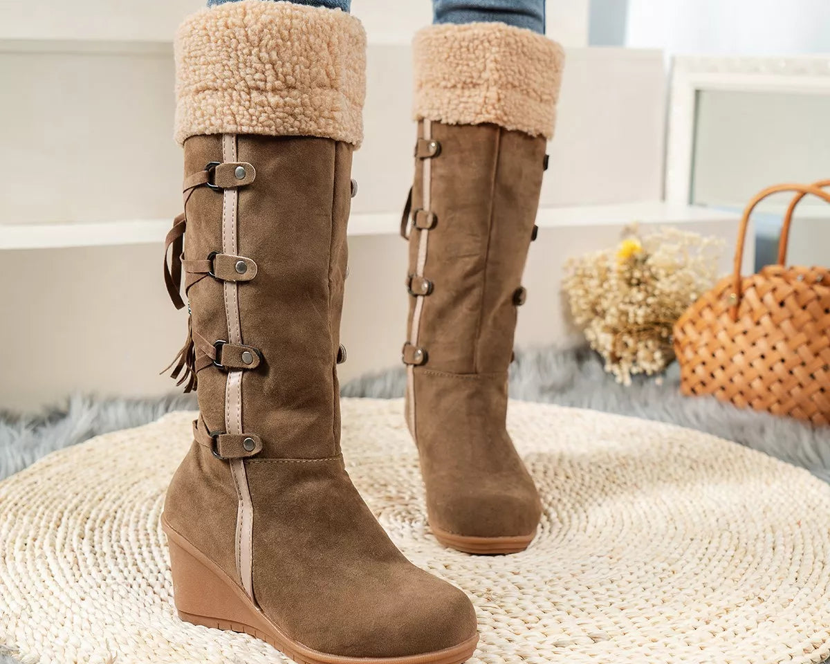 NEWYORKLISTED SHOE COLLECTION: Brown knee-high boots with fur trim worn by a person on a textured rug.