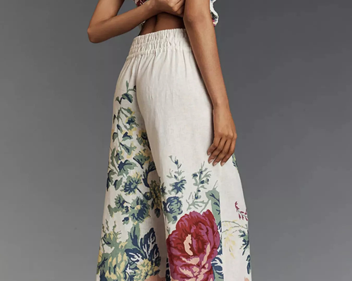 NEWYORKLISTED STYLE COLLECTION: Woman wearing a strapless top and floral pants against a gray background