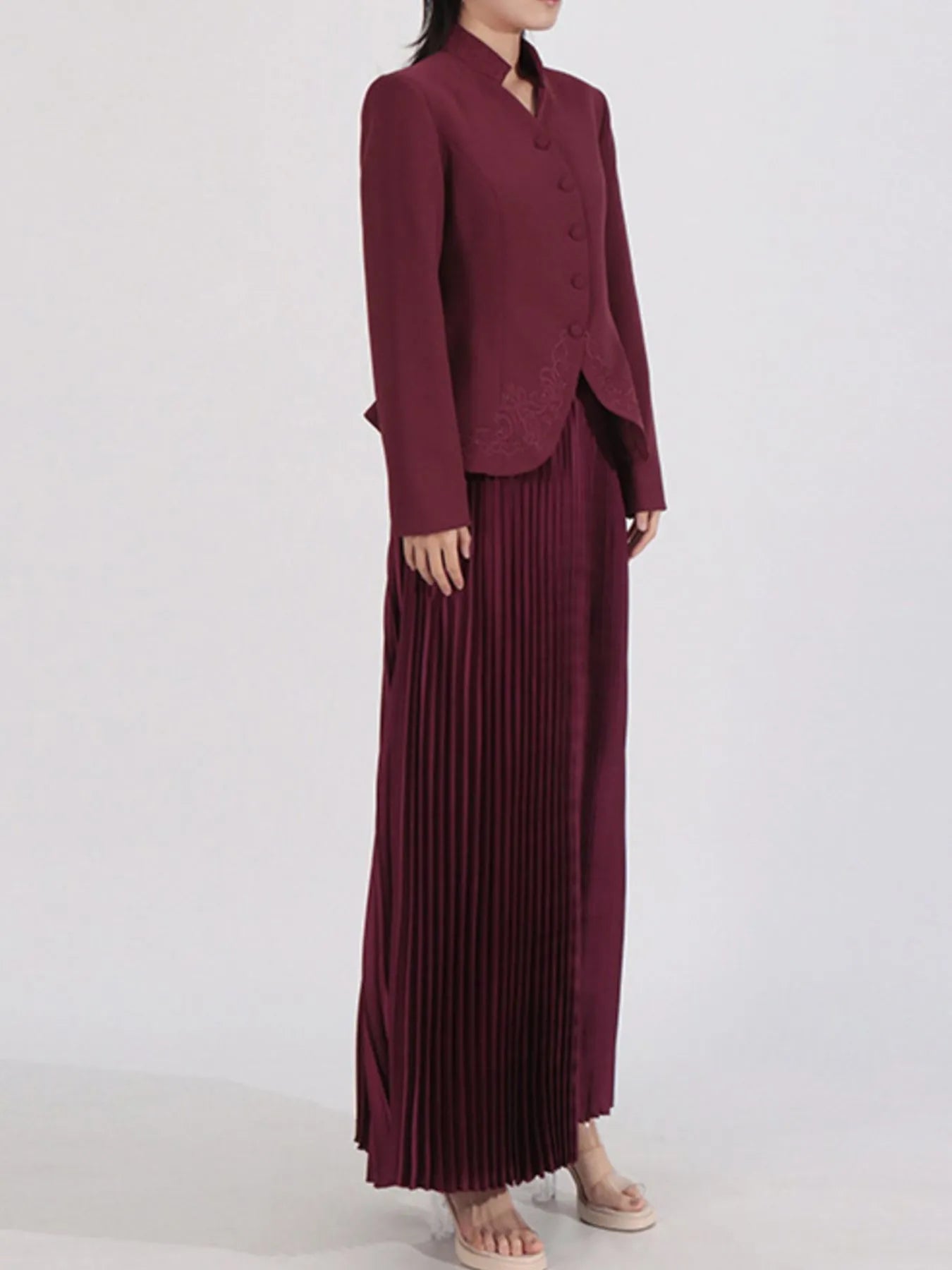 NEWYORKLISTED STYLE COLLECTION: Maroon suit with a long pleated skirt on a white background