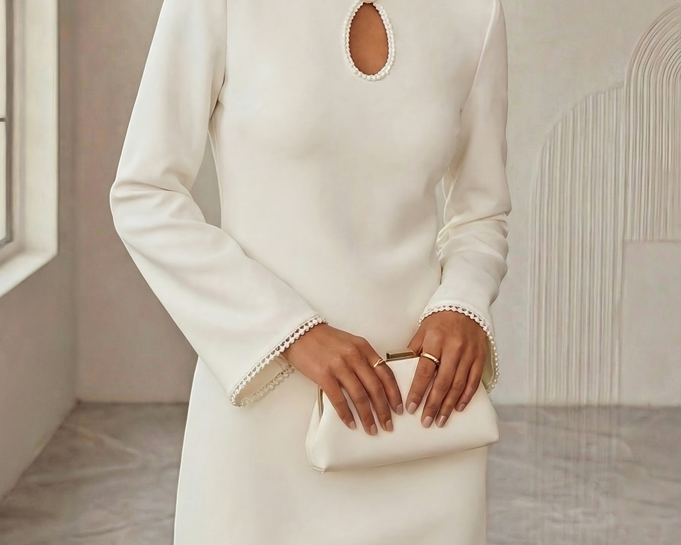 NEWYORKLISTED STYLE COLLECTION: Woman wearing a white dress with a cut-out design in a neutral setting