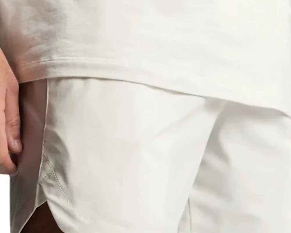 NEWYORKLISTED ATLAS MEN'S COLLECTION: Close-up of a person wearing a white t-shirt and beige shorts on a white background