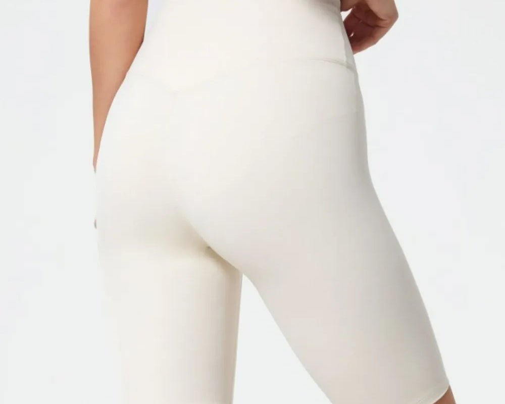 White athletic shorts worn by a person on a light gray background