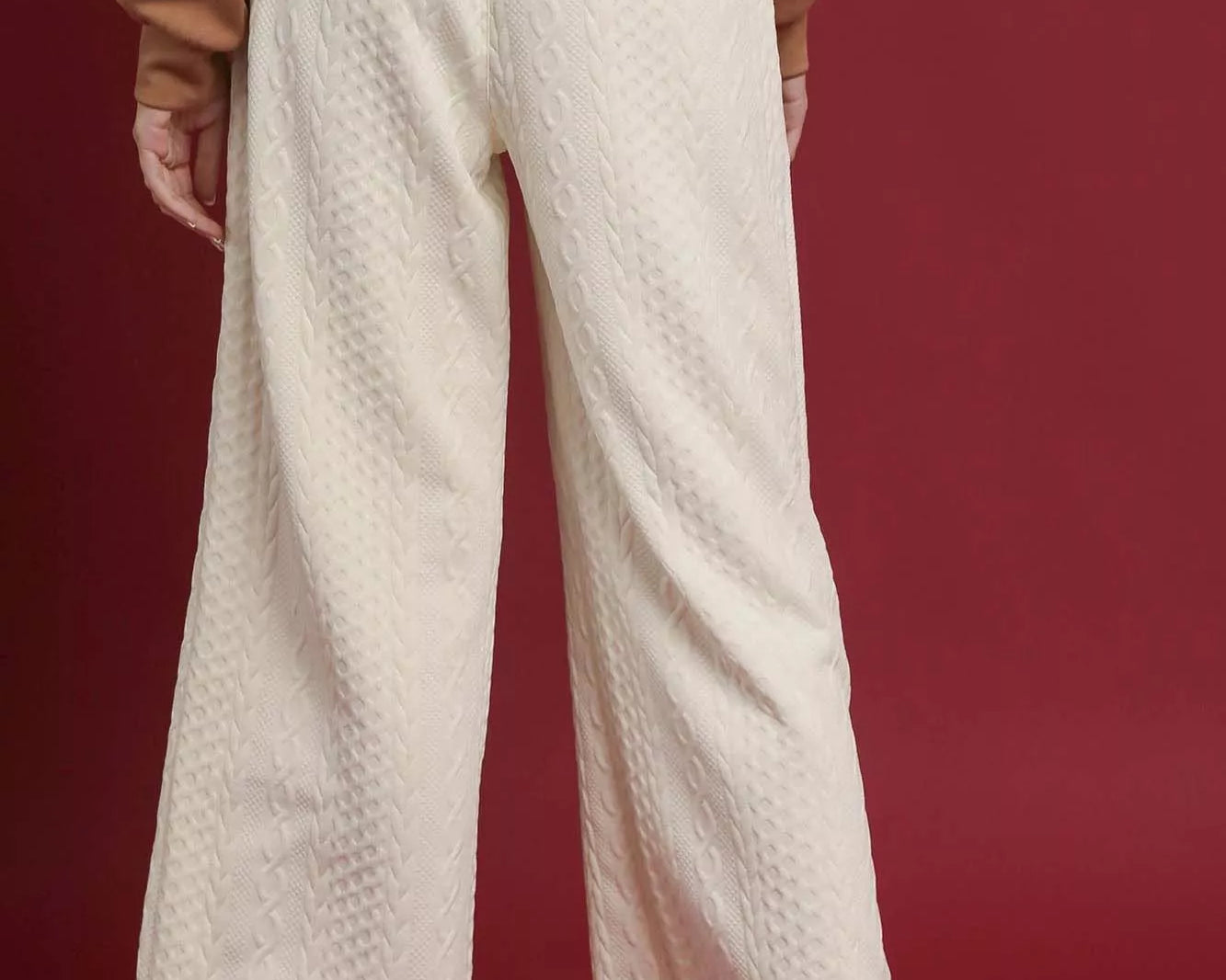 NEWYORKLISTED STYLE COLLECTION: Person wearing beige textured pants on a red background