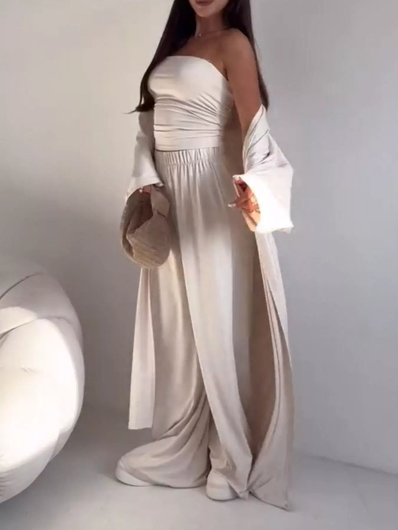 NEWYORKLISTED COMFORT COLLECTION: Woman wearing a white strapless dress with long sleeves against a plain background