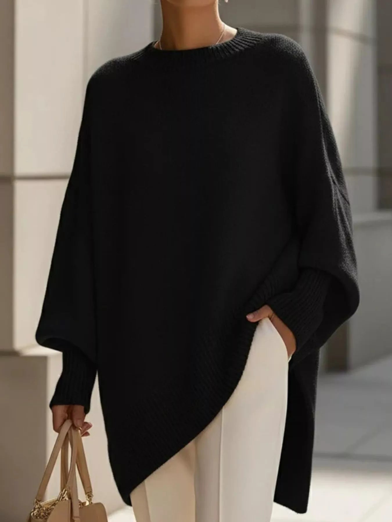 NEWYORKLISTED STYLE COLLECTION: Person wearing a black poncho in an indoor setting