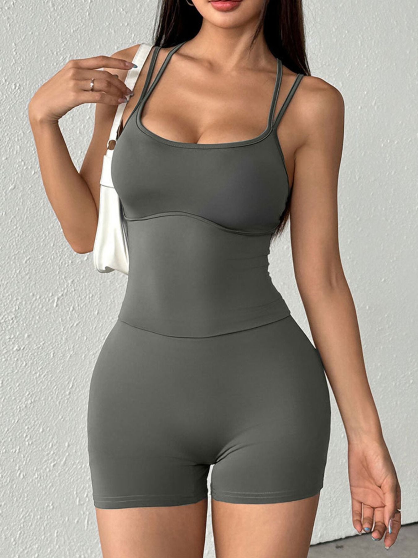NEWYORKLISTED ACTIVEWEAR COLLECTION: Woman wearing a gray athletic outfit against a light gray background