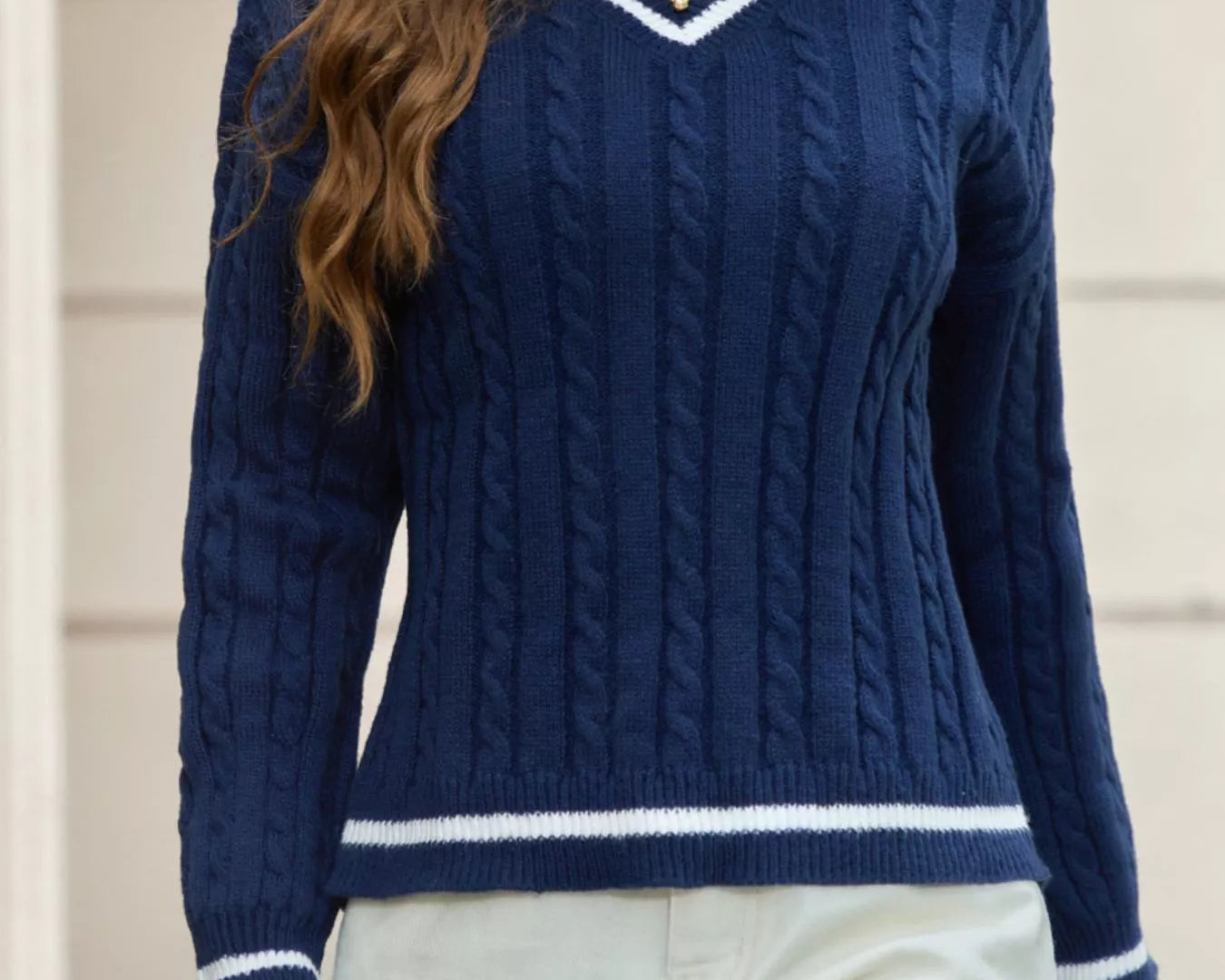 NEWYORKLISTED STYLE COLLECTION: Woman wearing a blue cable knit sweater with white trim.