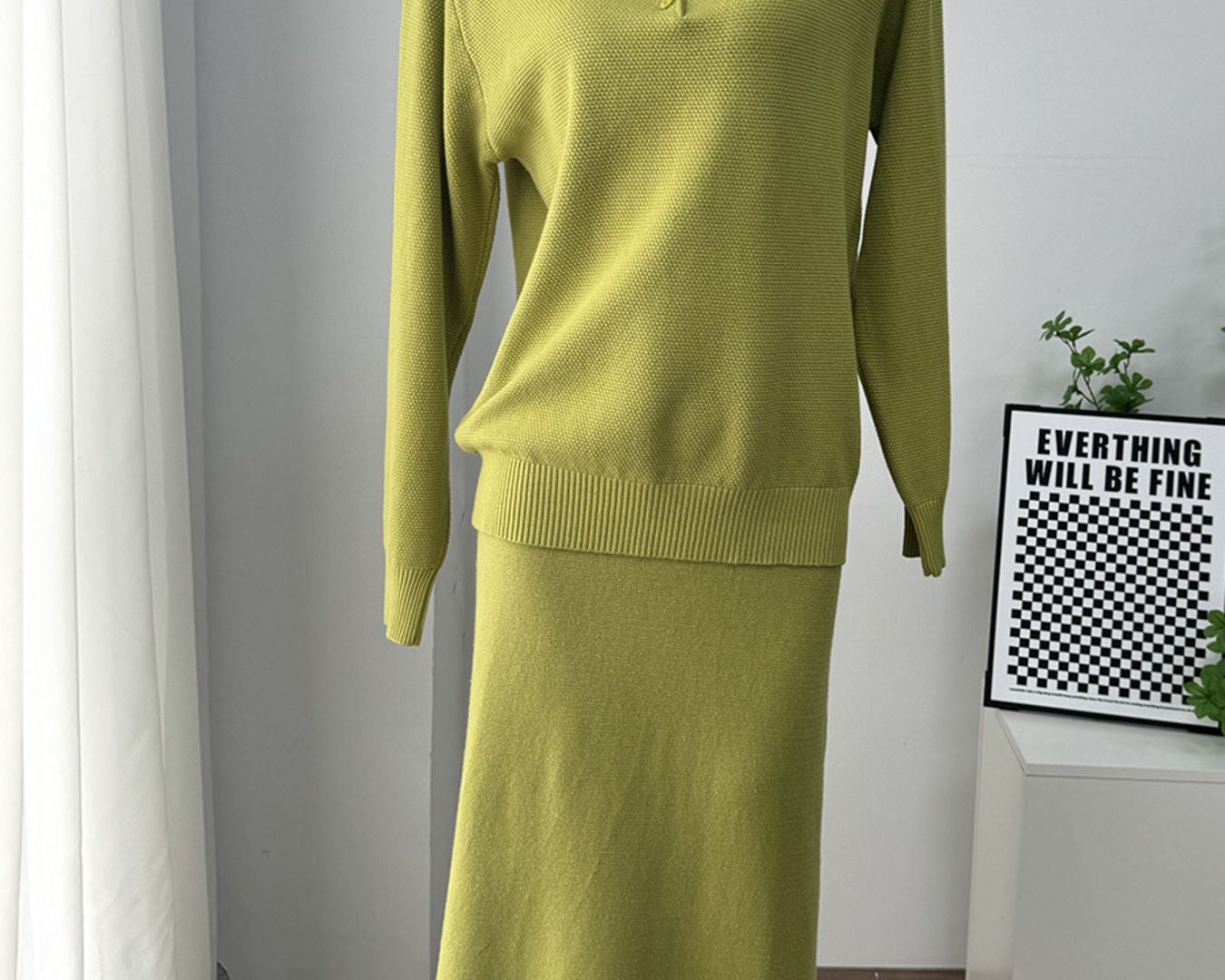 NEWYORKLISTED Comfort Collection: Green sweater and skirt set on a mannequin against a white wall.
