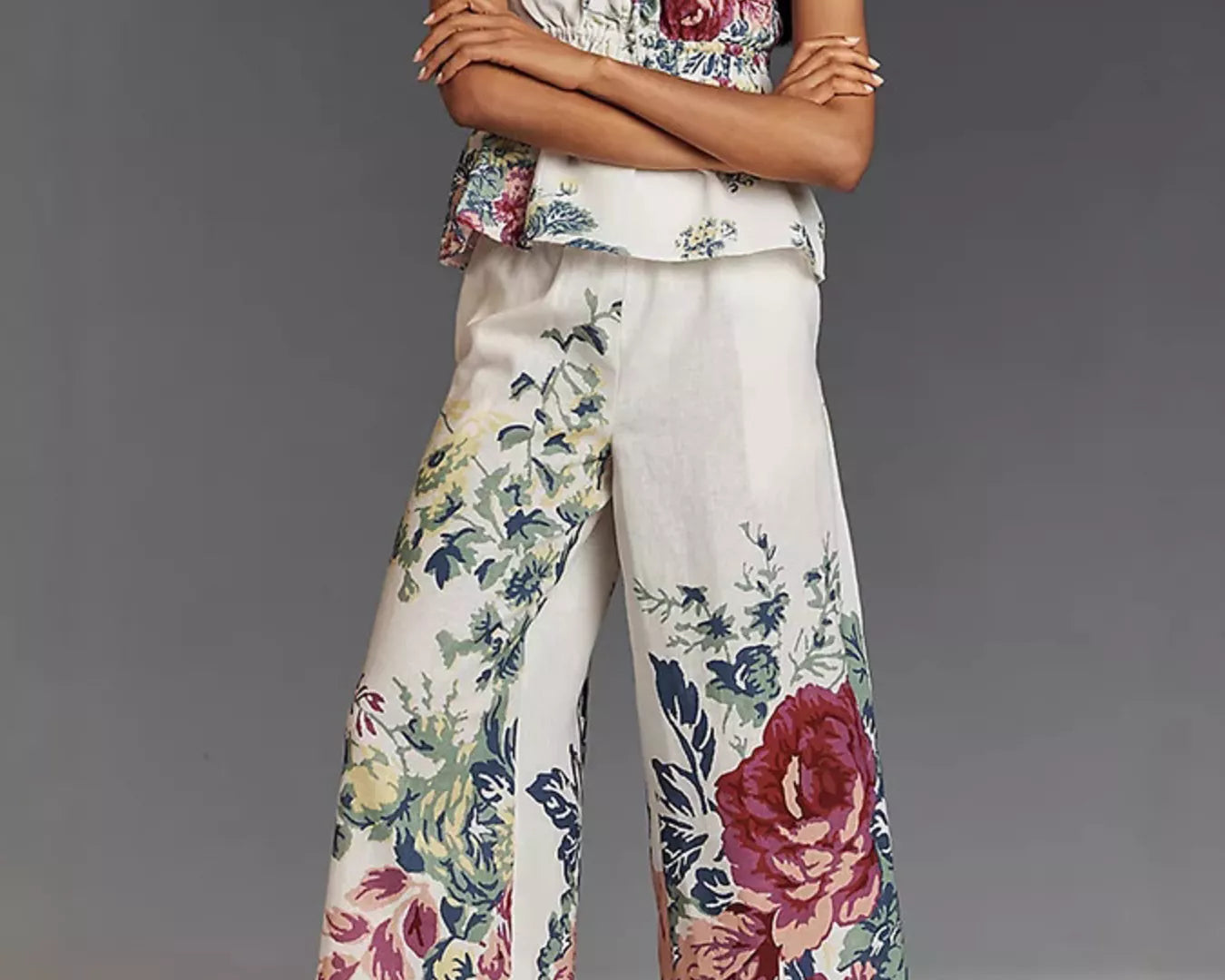 NEWORKLISTED STYLE COLLECTION: Woman wearing a floral top and wide-leg pants against a gray background