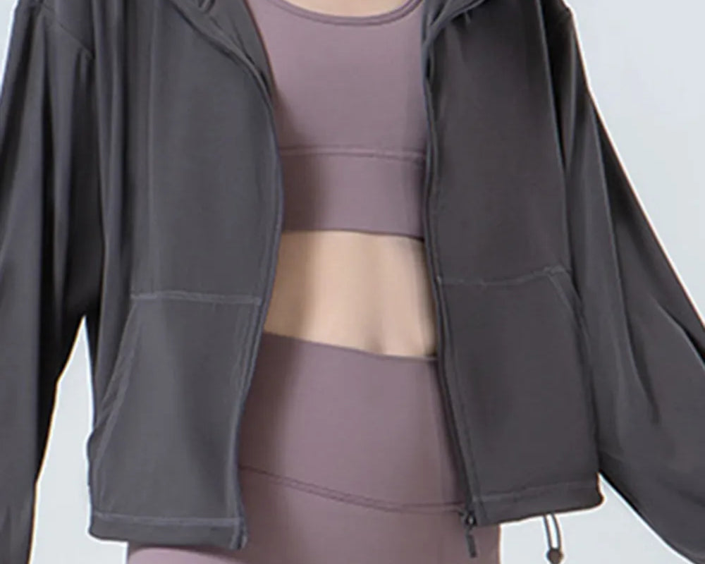 NEWYORKLISTED ACTIVEWEAR COLLECTION: Person wearing a gray jacket over a matching athletic outfit on a plain background