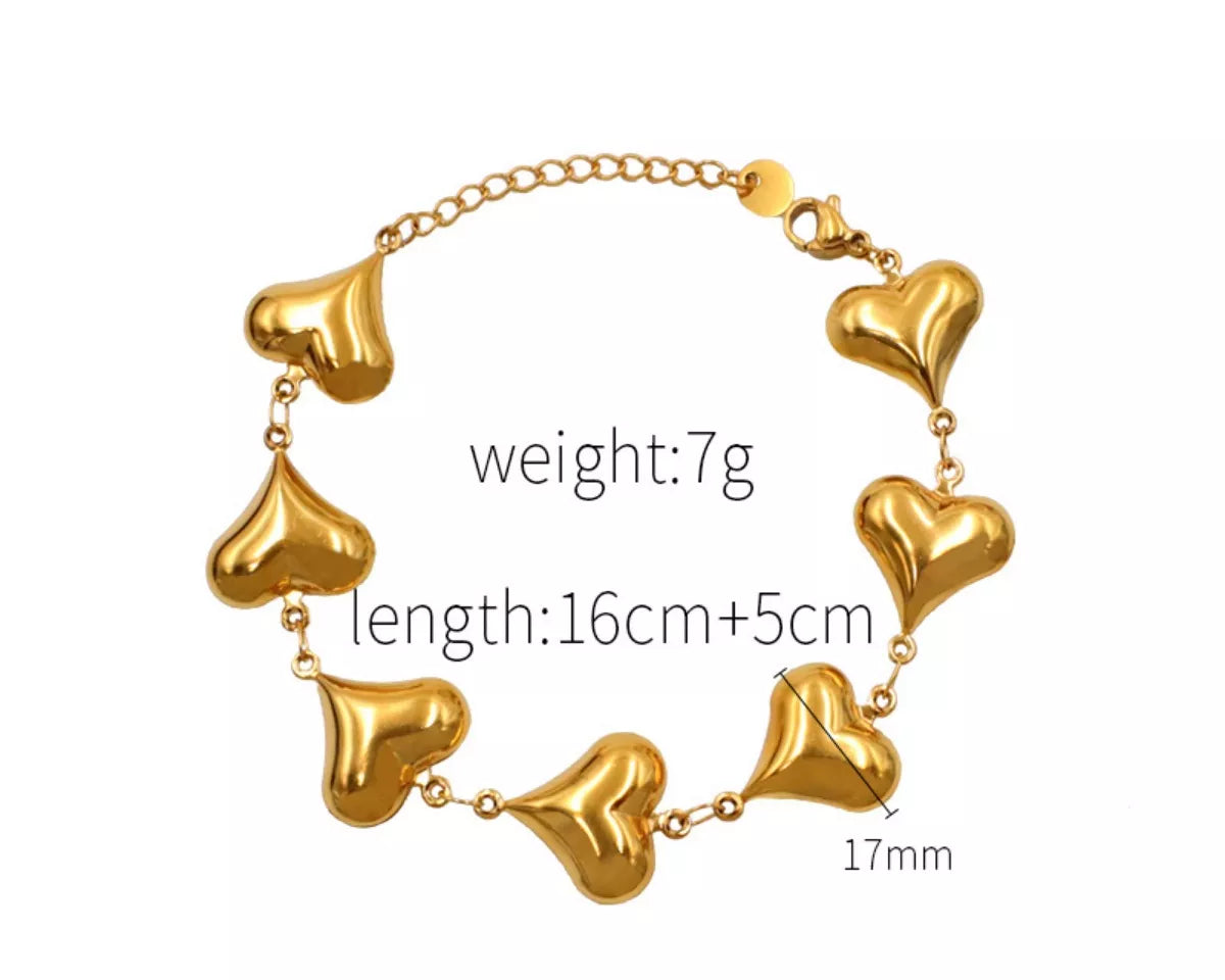 NYLD Glamour Collection by NEWYORKLISTED: Gold heart-shaped bracelet with measurements on a white background