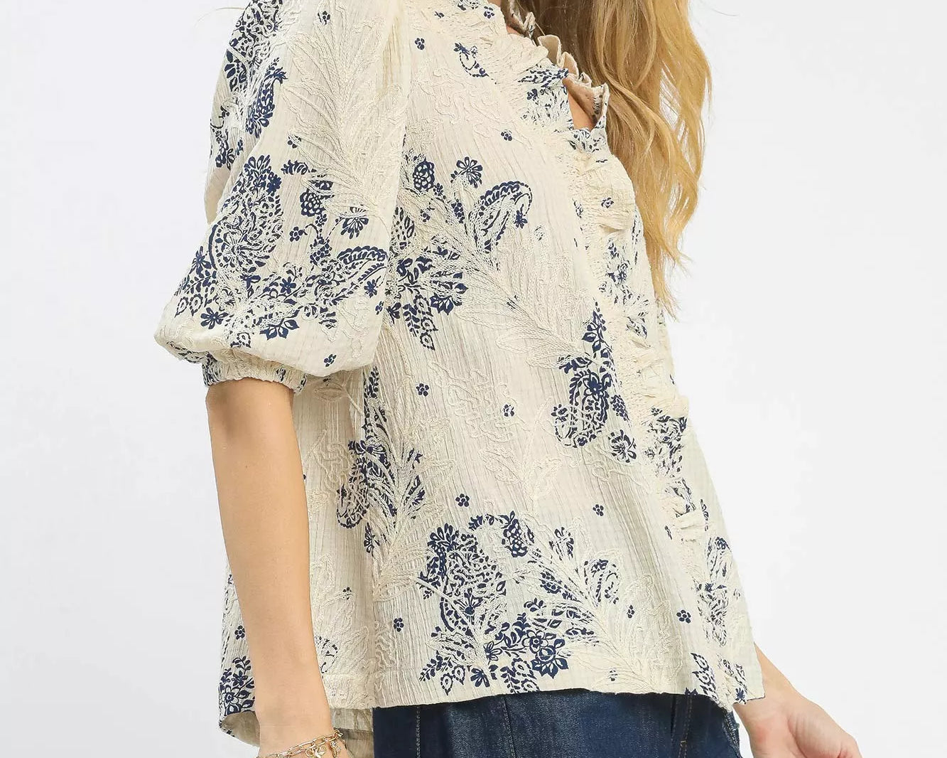 NEWYORKLISTED STYLE COLLECTION: Woman wearing a floral blouse with navy accents on a white background