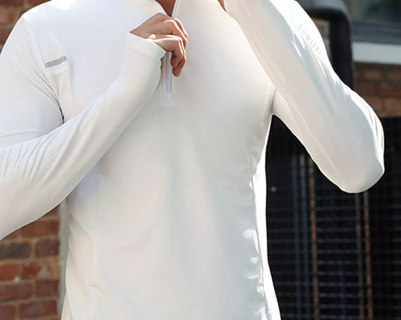 NEWYORKLISTED ATLAS MEN'S COLLECTION: Person wearing a white long-sleeve shirt with a zipper, standing against a brick wall.
