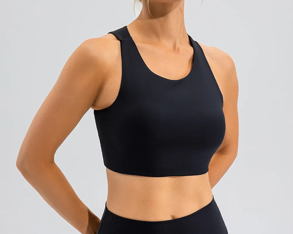 NEWYORKLISTED ACTIVEWEAR COLLECTION: Woman wearing a black sports bra and leggings on a light gray background