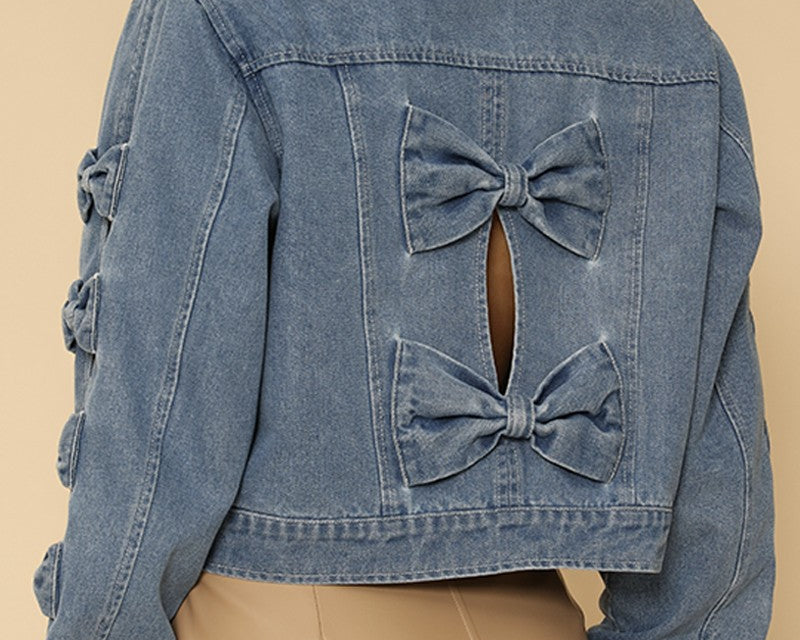 NEWYORKLISTED STYLE COLLECTION: Blue denim jacket with bow details on a beige background