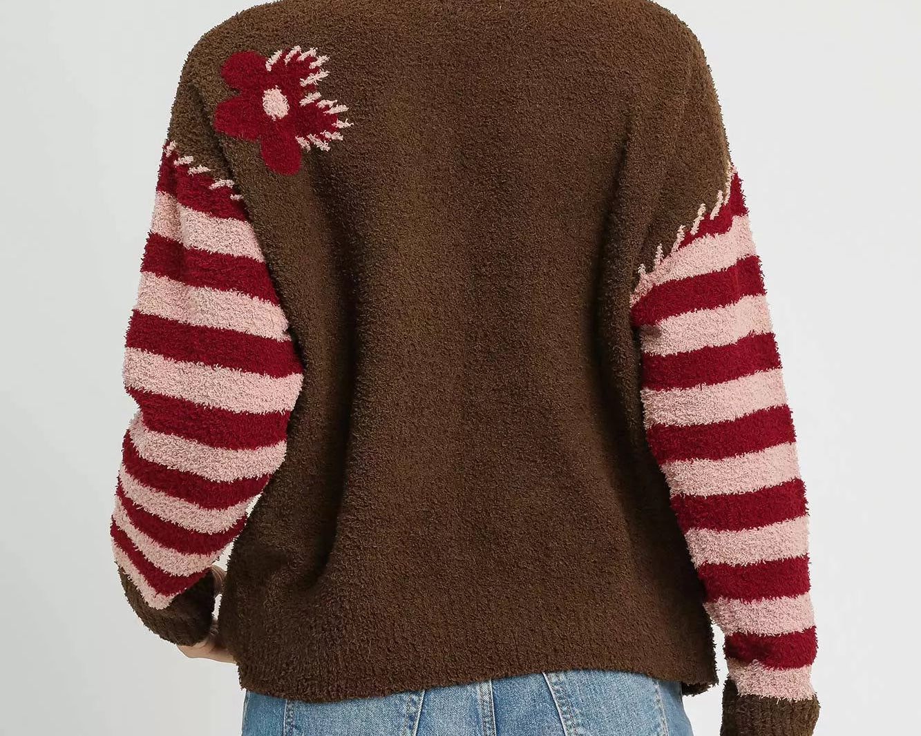 NEWYORKLISTED STYLE COLLECTION: Person wearing a brown sweater with red and white pattern, standing against a plain background