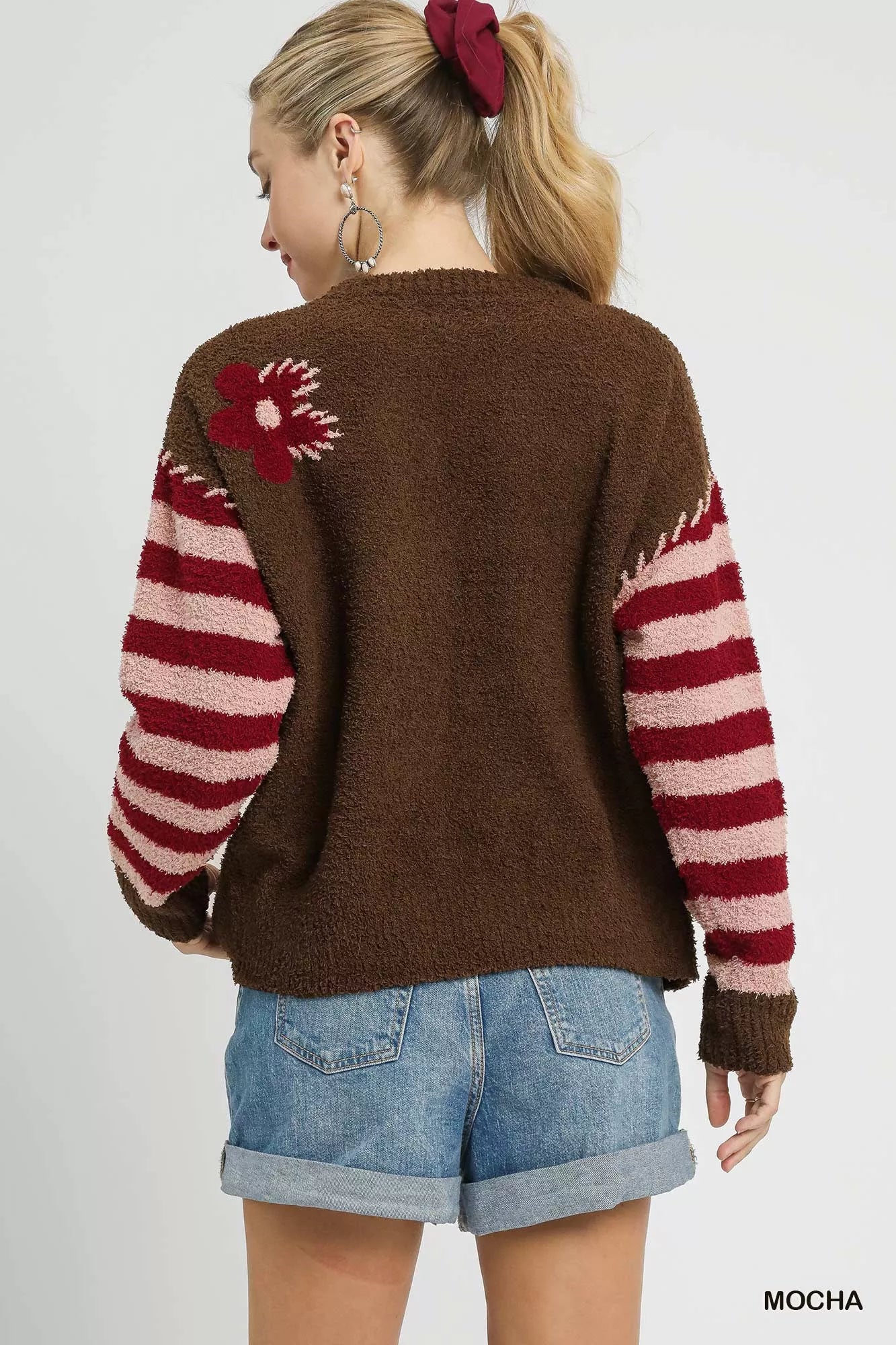 NEWYORKLISTED STYLE COLLECTION: Person wearing a brown sweater with red and white pattern, standing against a plain background
