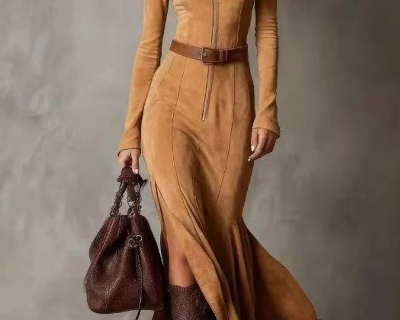 NEWYORKLISTED STYLE COLLECTION: Woman wearing a long brown dress with a belt and holding a matching handbag against a neutral background