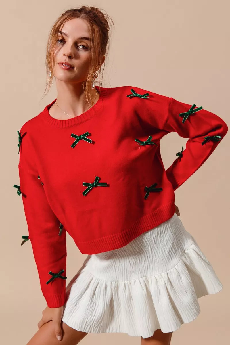 NEWYORKLISTED STYLE COLLECTION: Woman wearing a red sweater with green bows and a white skirt on a beige background
