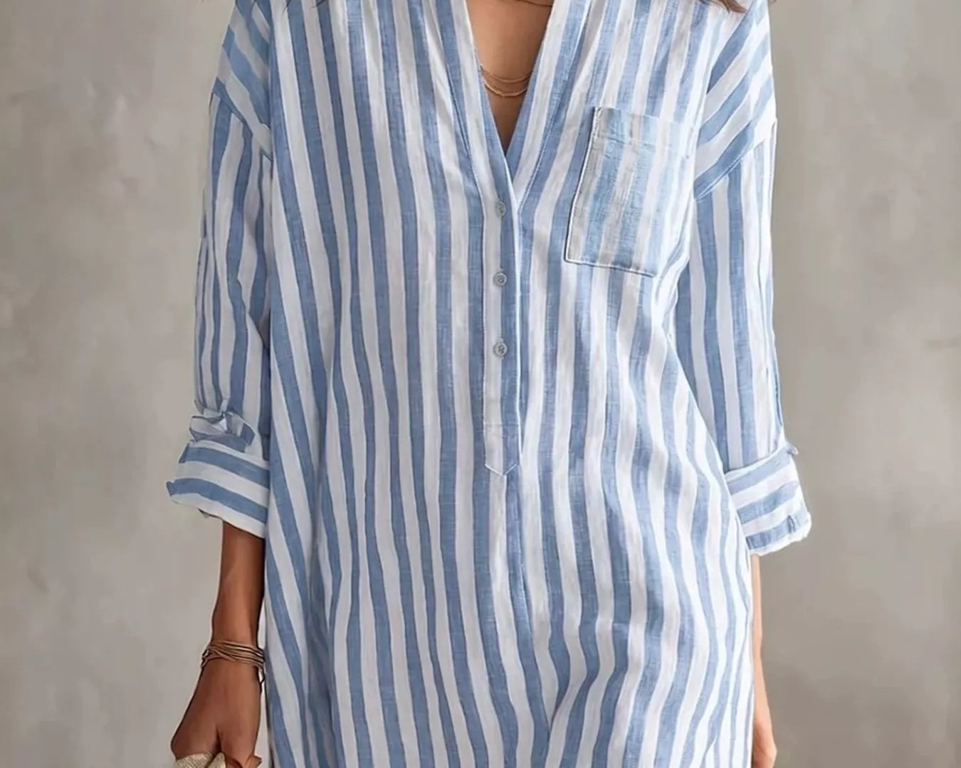 NEWYORKLISTED STYLE COLLECTION: Woman wearing a blue and white striped dress against a neutral background