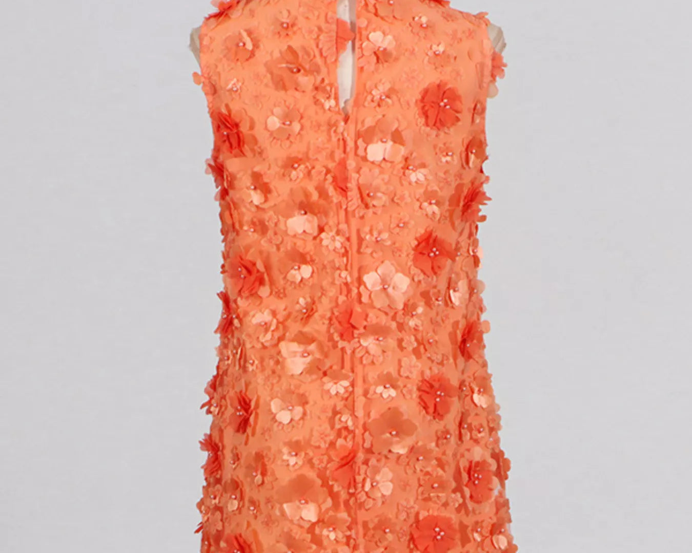 NEWYORKLISTED STYLE COLLECTION: Coral floral dress on a mannequin against a light gray background