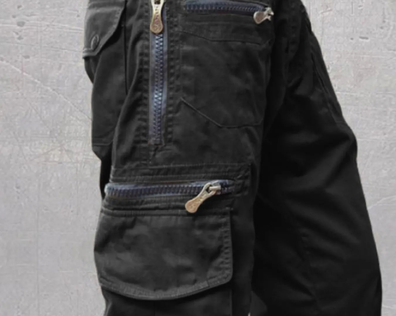 NEWYORKLISTED ATLAS MEN'S COLLECTION: Black tactical shorts with multiple pockets and zippers on a gray background