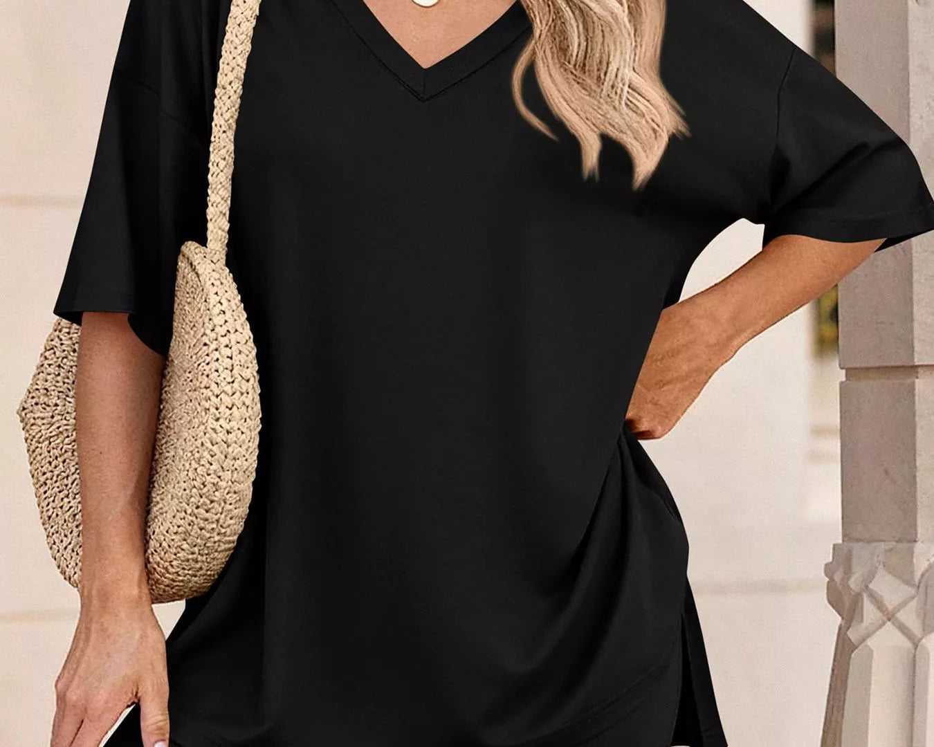 NEWYORKLISTED COMFORT COLLECTION: Woman wearing a black outfit with a straw bag against a neutral background