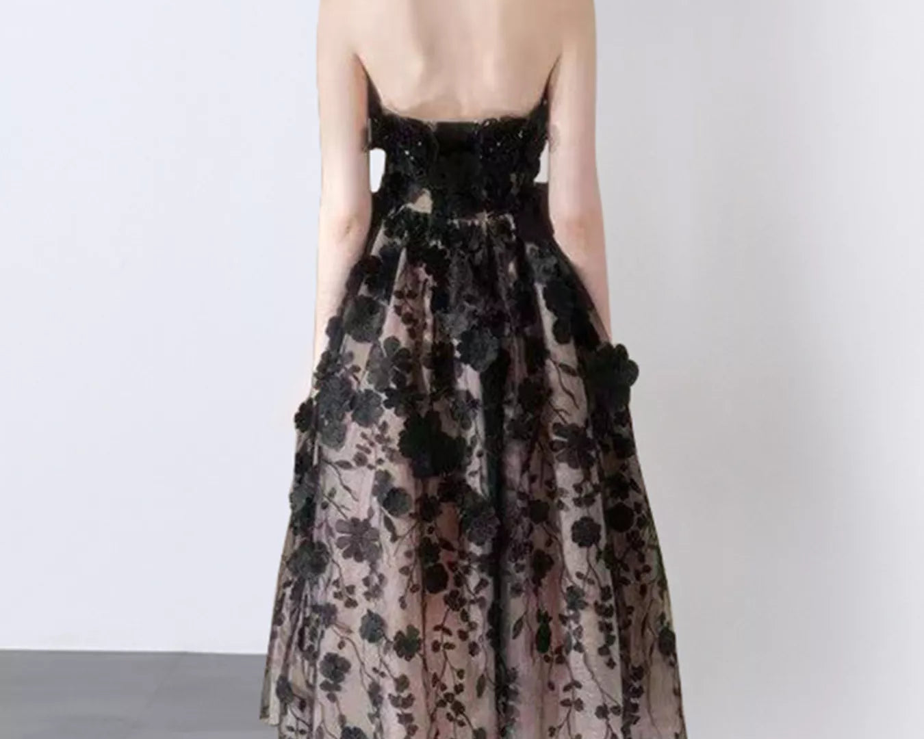 NEWYORKLISTED STYLE COLLECTION: Woman wearing a floral dress with a plain background