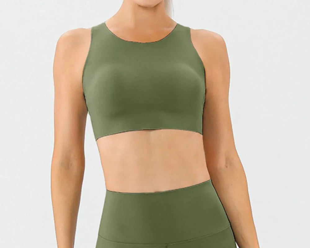NEWYORKLISTED ACTIVEWEAR COLLECTION: Woman wearing an olive green sports bra and leggings set on a white background