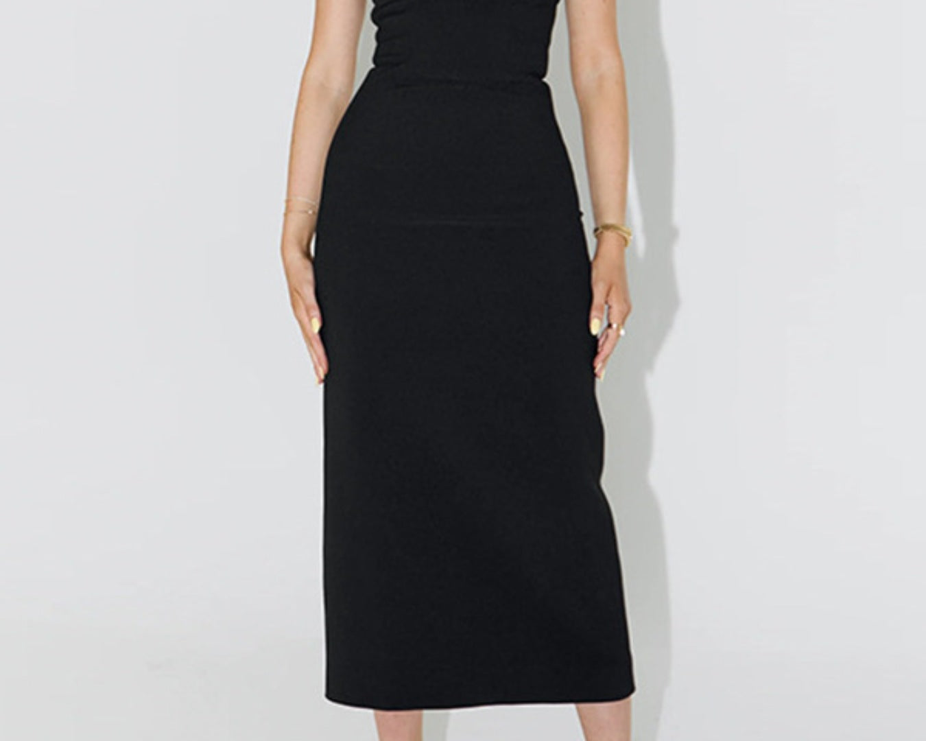 NEWYORKLISTED STYLE COLLECTION: Black halter neck dress worn by a person on a white background