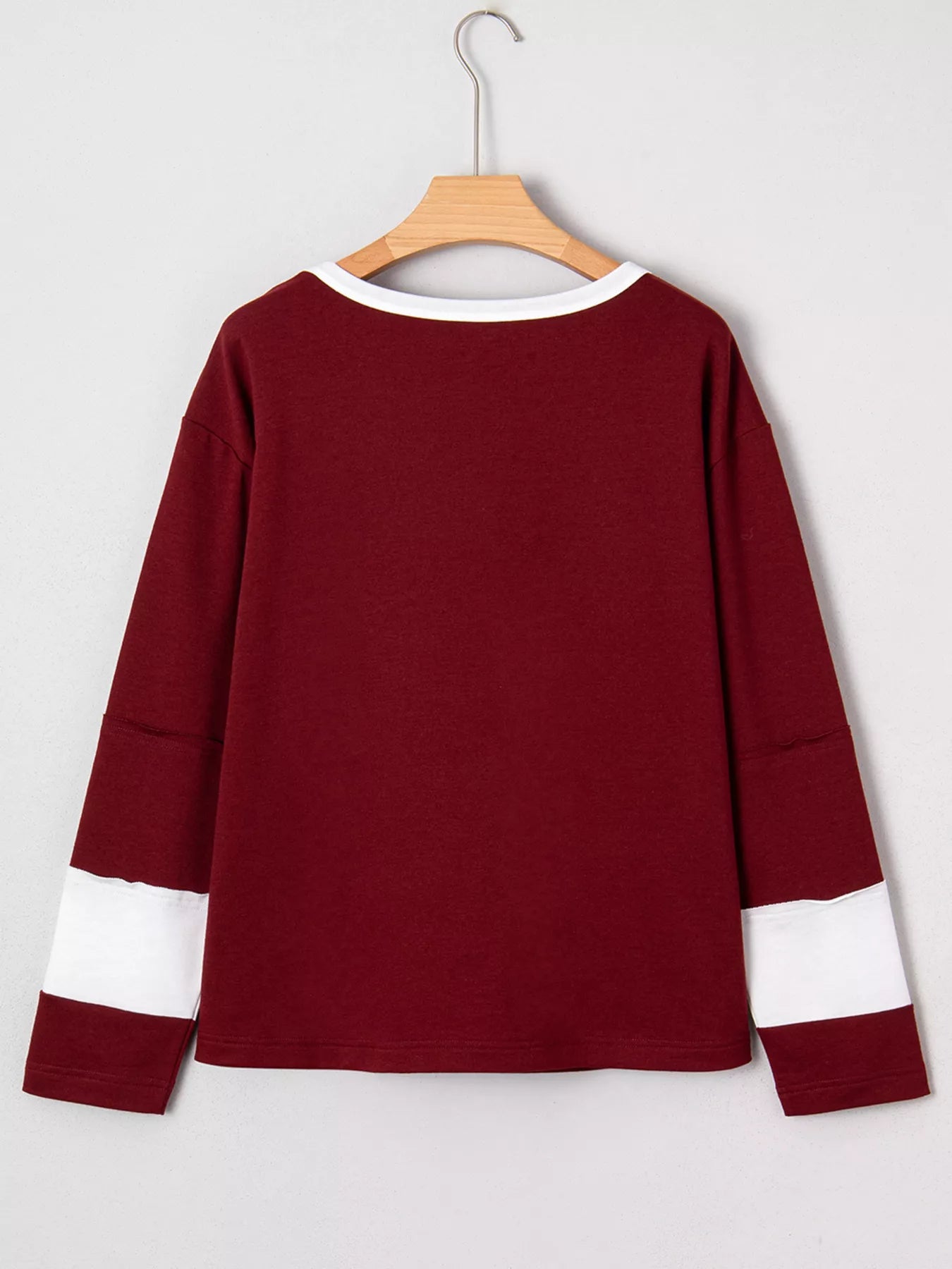 NEWYORKLISTED STYLE COLLECTION: Maroon long-sleeve shirt with white accents on a hanger against a light gray background
