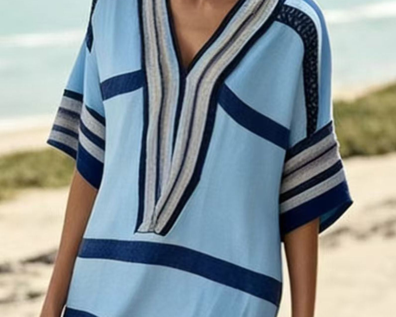 NEWYORKLISTED STYLE COLLECTION: Woman wearing a blue and white striped dress on a beach