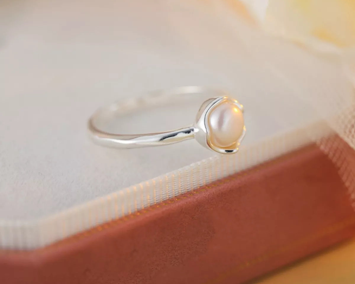 NYLD Glamour By NEWYORKLSITED: Sterling silver ring with a freshwater pearl on a soft fabric background