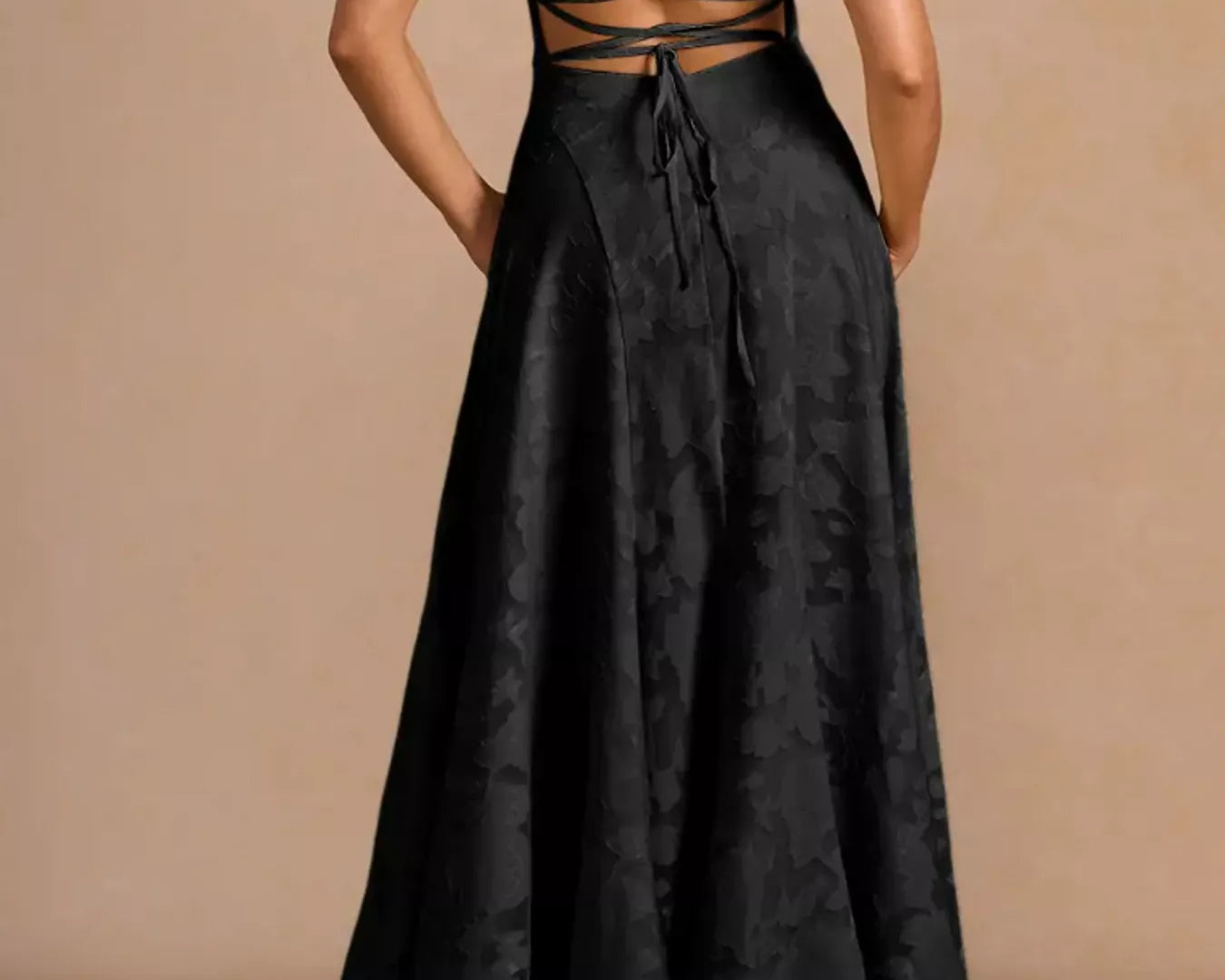 NEWYORKLISTED STYLE COLLECTION: Black dress with criss-cross back design on a beige background