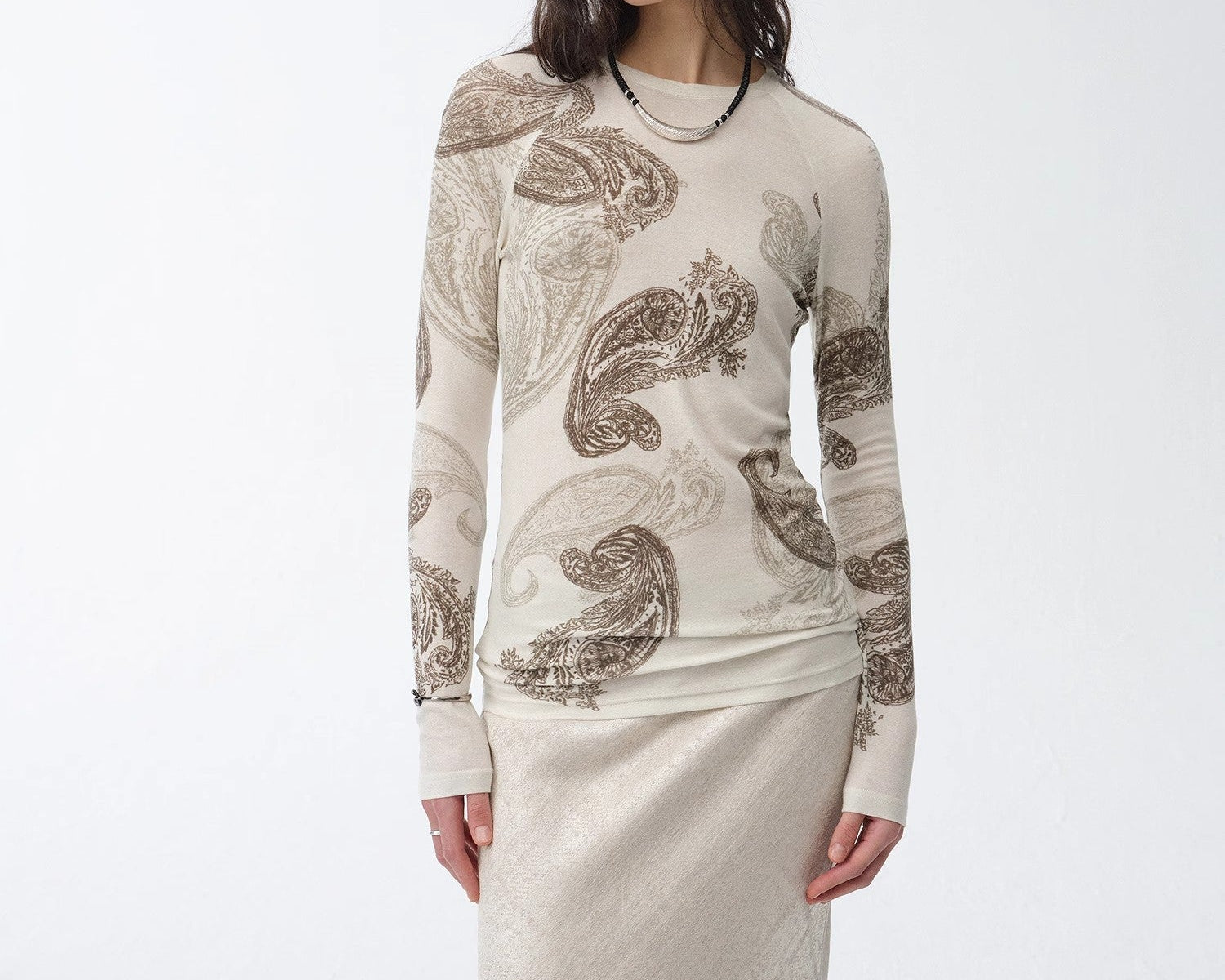 Woman wearing a long-sleeve top with a pattern on a white background