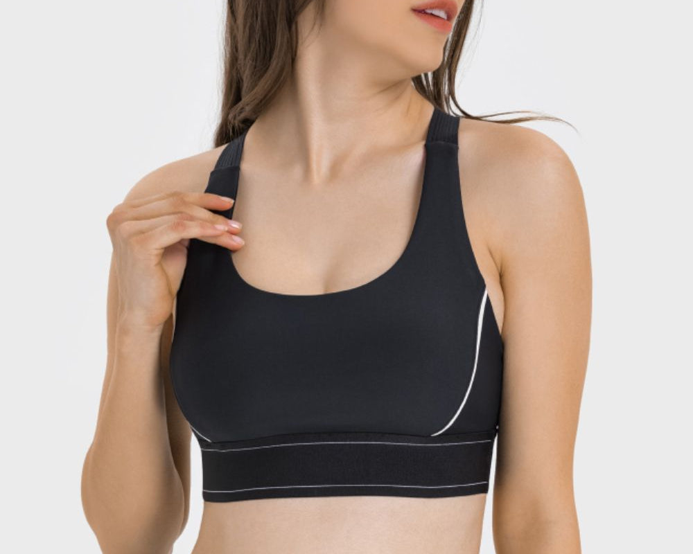 NEWYORKLISTED ACTIVEWEAR COLLECTION: Woman wearing a black sports bra and leggings on a white background